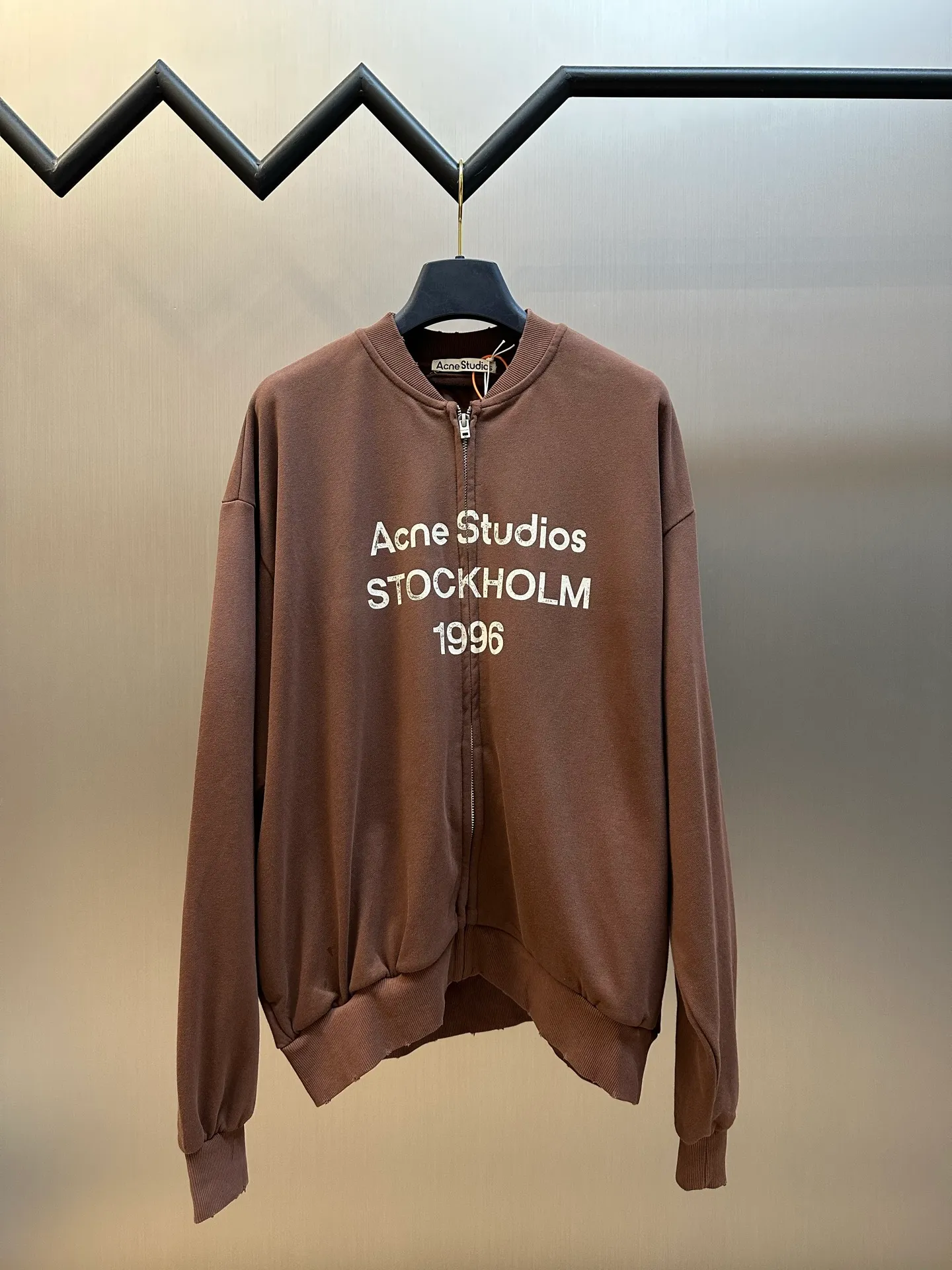 Ac Studios spray-painted distressed logo baseball collar jacket, custom-ordered soft velvet fleece cotton, Classic baseball collar zipper jacket has a neat and elegant silhouette, with dropped shoulders for a relaxed and casual fit, and densely woven ribbing to show craftsmanship details. The Ac Studios logo is printed on the chest, using Retro sports aesthetics to engrave the brand's heritage. It is unobtrusive but highly recognizable. It perfectly blends Nordic minimalist style with Retro sports style. Adopting the glue printing process, the chest printing is modified by the film screen three times, the glue liquid paint is used to print the pattern on the fabric, and the fabric is baked to fix the printed pattern. The gradient distressed spray process sprays dyes of different colors on the surface of the fabric to achieve rich color changes under different lights and increase the visual layering. Many parts of the body of the garment are frayed by purely artificial regular positioning, and hand-brushed marks add texture and depth to the surface of the garment to imitate the texture of natural wear and tear size: s m l xl